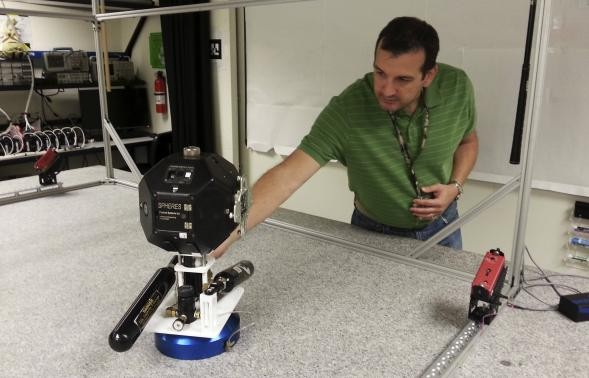 Smart SPHERES project manager Chris Provencher demonstrates one of NASA's robots at the Ames Research Center in Mountain View, California