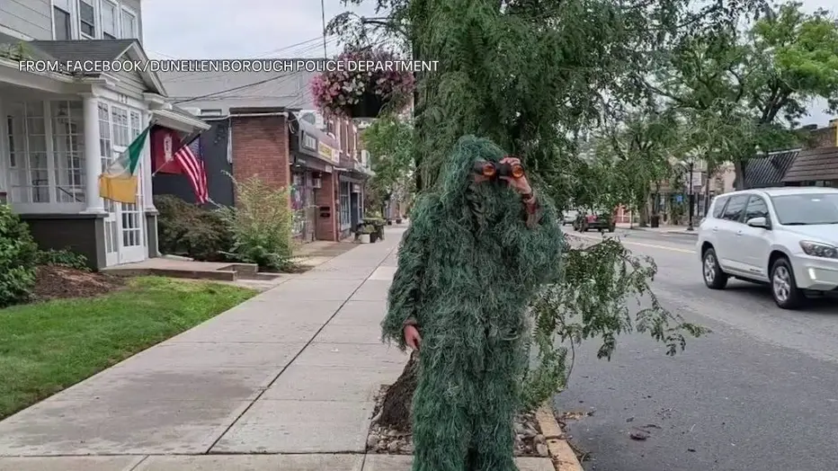 Φωτογραφία από την επίσημη σελίδα του Dunellen Borough Police Department που δείχνει τον αστυνομικό να είναι καλυμμένος με ενδυμασία που μοιάζει σε θάμνο