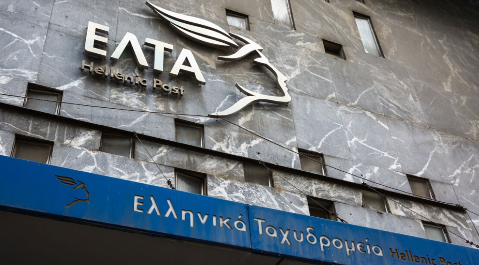 Η φωτογραφία απεικονίζει το λογότυπο - ταμπέλα των ΕΛΤΑ σε κατάστημα των Ελληνικών Ταχυδρομείων.